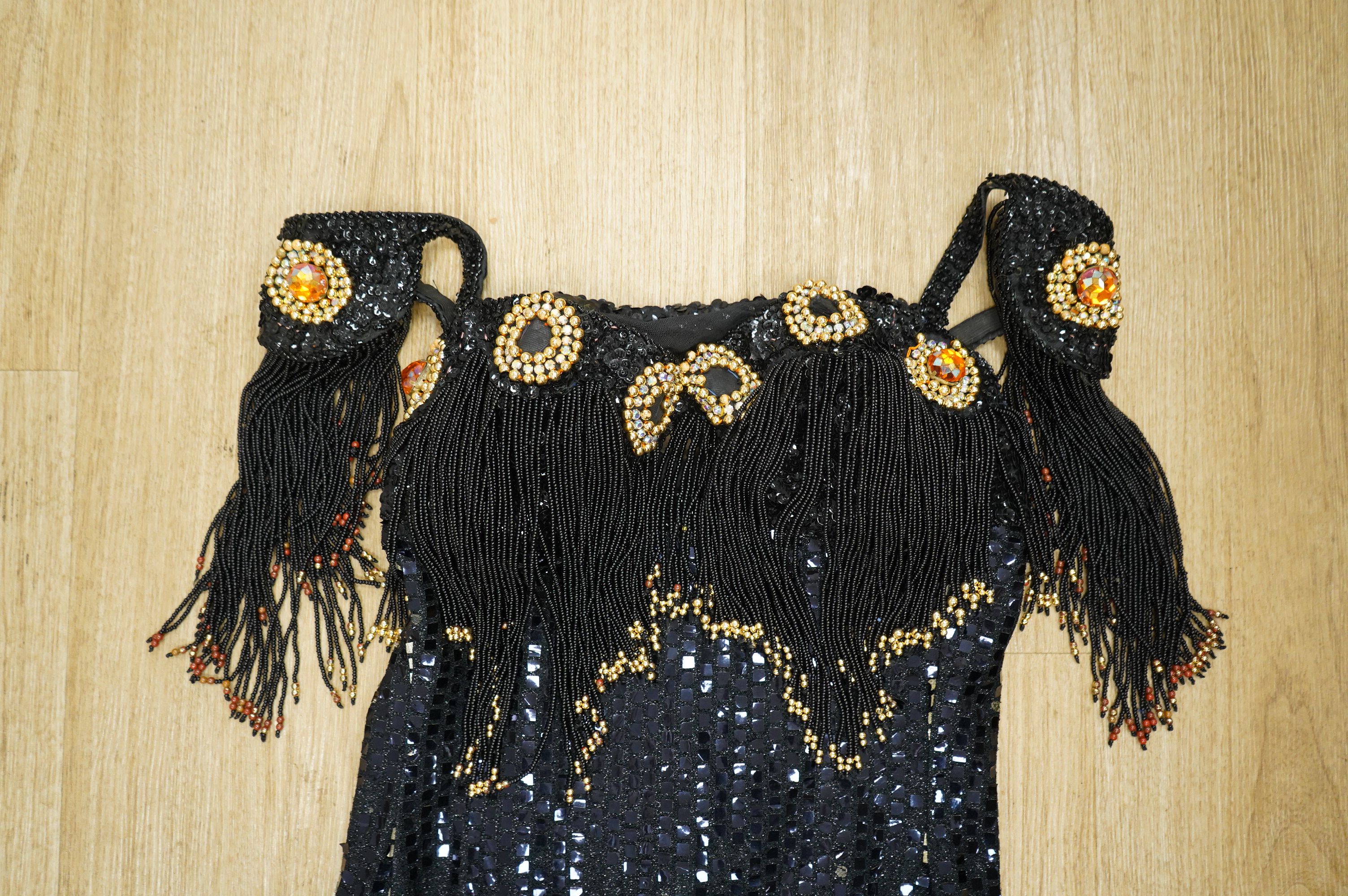 A late 20th century black sequinned, beaded and fringed evening dress, bust 36cm wide at front, together with a lilac chiffon, net, lace and sequin top and matching net evening skirt. Both outfits are a small size